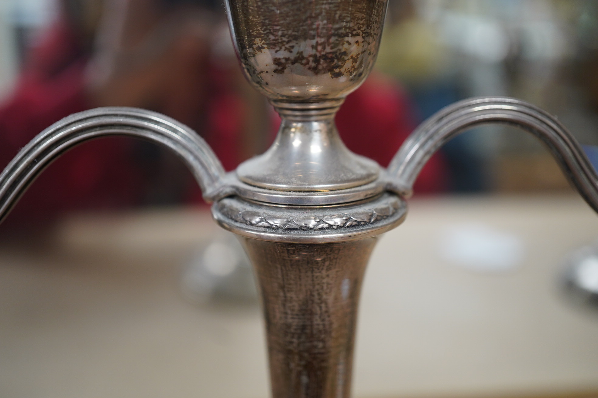 A pair of Elizabeth II silver candlesticks, Broadway & Co, Birmingham, 1960, 25.7cm, weighted, together with a similar silver three light candelabrum, by Adie Bros, weighted. Condition - poor to fair